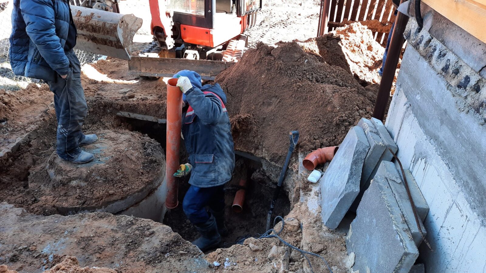 construction-worker-assembles-sewer-pipes-into