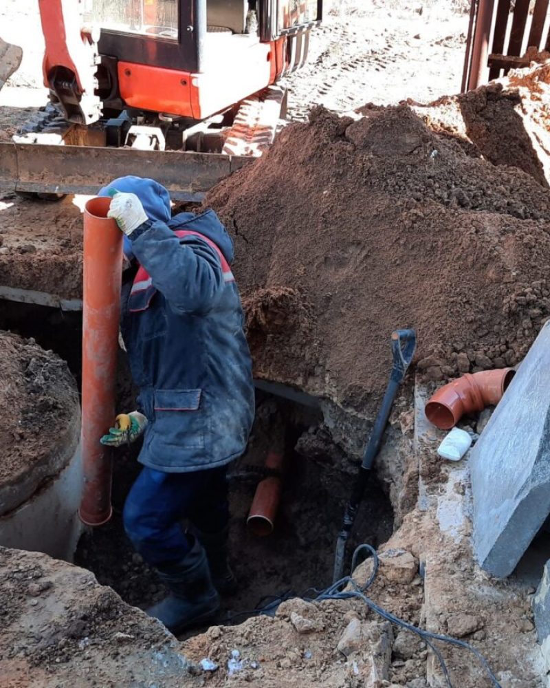 construction-worker-assembles-sewer-pipes-into